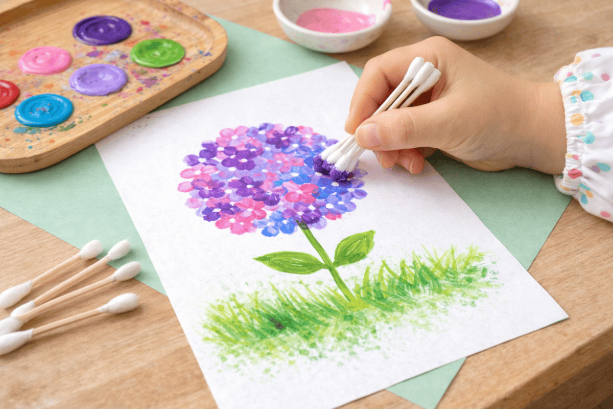 Kind tupft mit Wattestäbchen bunte Blumen auf Papier in einer selbst gemalten Wiese