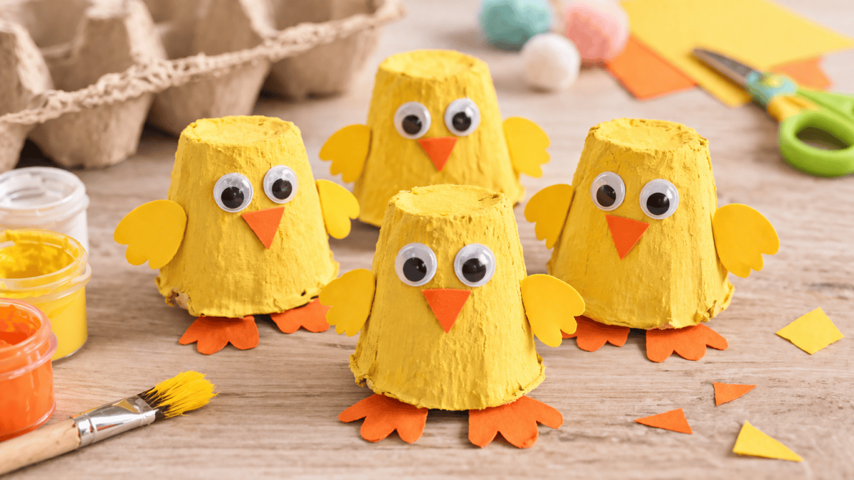Gebastelte Küken aus einem Eierkarton, gelb bemalt und mit Schnabel, Füßen und Augen gestaltet
