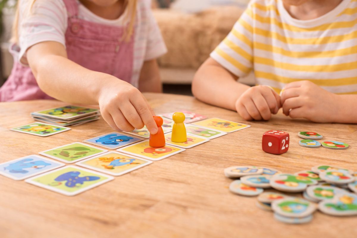 Kinder spielen ein einfaches Gesellschaftsspiel mit Karten und Figuren – Spiele ab 4 Jahren mit kurzen Regeln und schnellem Einstieg
