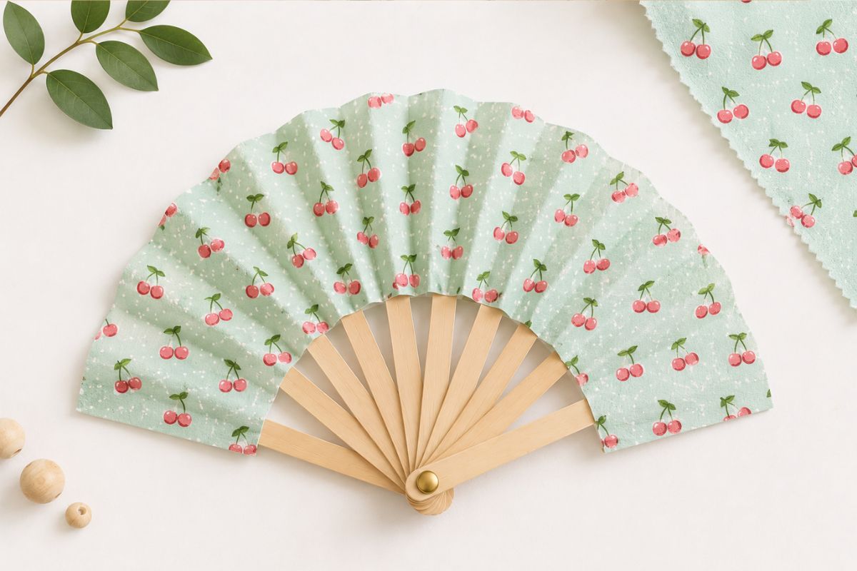 Selbst gebastelter Sommerfächer aus Holzstäbchen und gemustertem Stoff als kreative Bastelidee für Kinder.