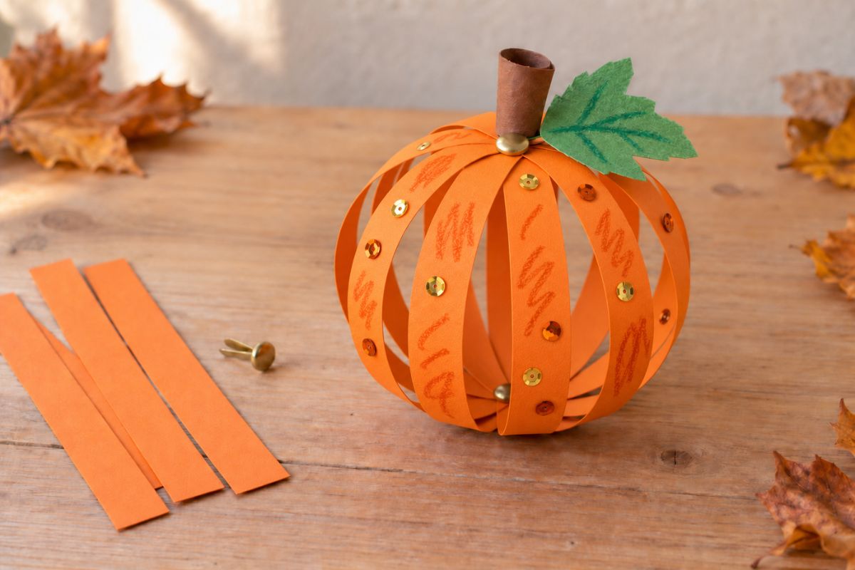 Herbst basteln mit Kindern – runden Kürbis aus orangefarbenen Papierstreifen basteln