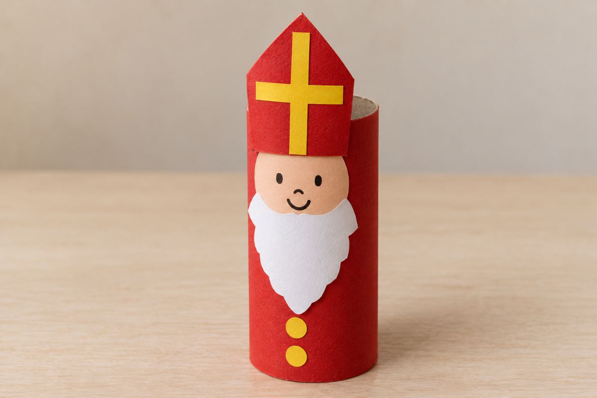 Nikolaus aus einer rot beklebten Klopapierrolle mit weißem Papierbart, aufgemaltem Gesicht und roter Bischofsmütze mit gelbem Kreuz.