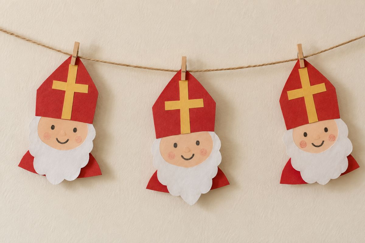 Girlande mit drei gebastelten Nikoläusen aus Papier an einer Schnur mit kleinen Holzklammern.