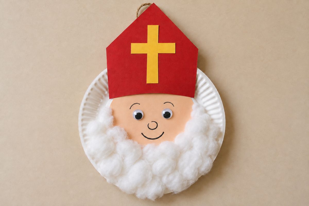 Nikolaus aus einem Pappteller mit weißem Wattebart, Wackelaugen und roter Bischofsmütze mit gelbem Papierkreuz.