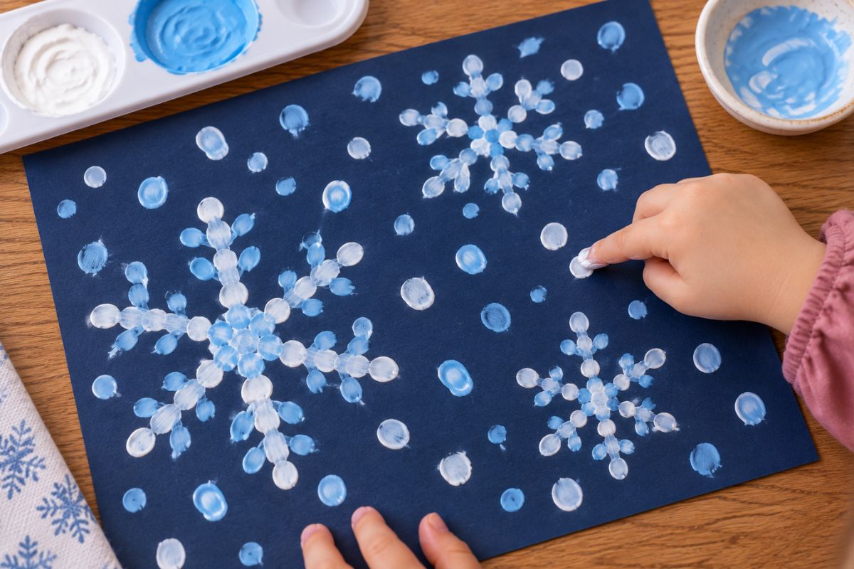 Schneeflocken mit Fingerfarben auf dunklem Papier gestalten – einfache Winter-Bastelidee für Kinder