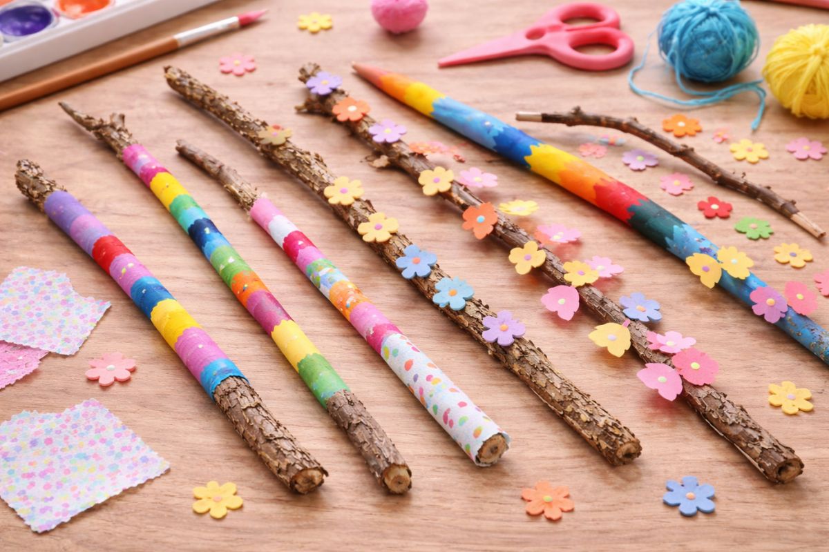bemalte und dekorierte Stöcke von Kindern mit Farbe, Wolle und Papier als einfache Frühlings-Bastelidee